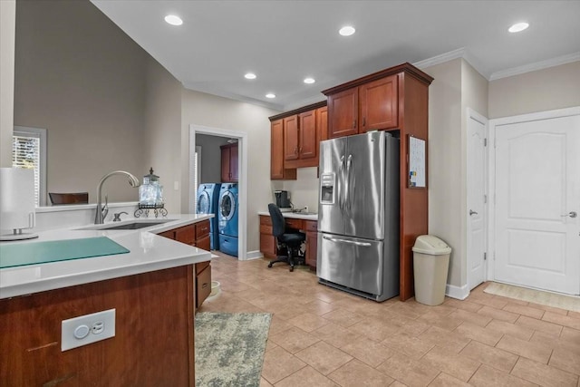 kitchen featuring sink, crown molding, stainless steel fridge, and washer and dryer