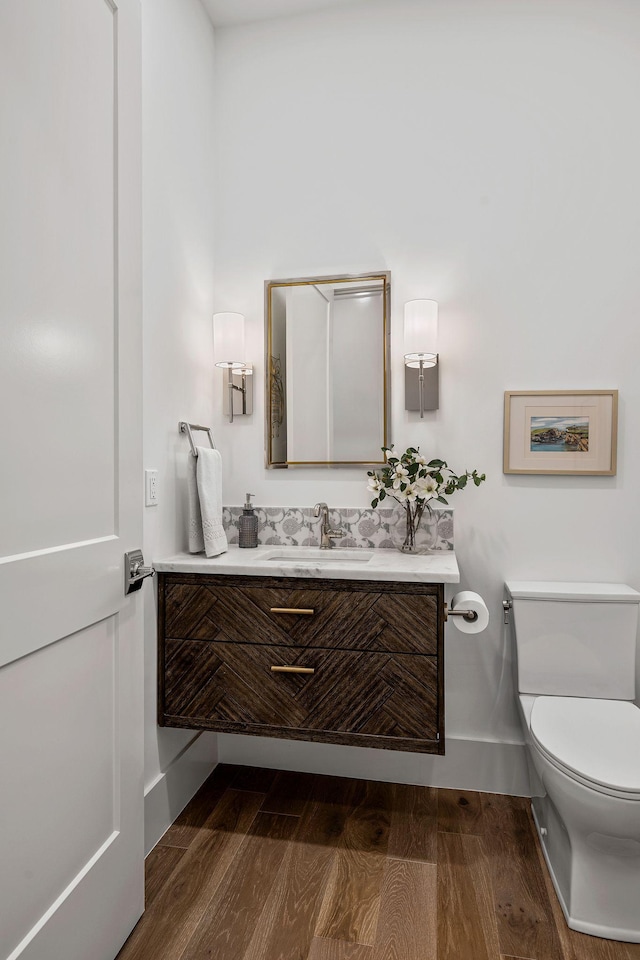 bathroom featuring vanity, wood-type flooring, and toilet