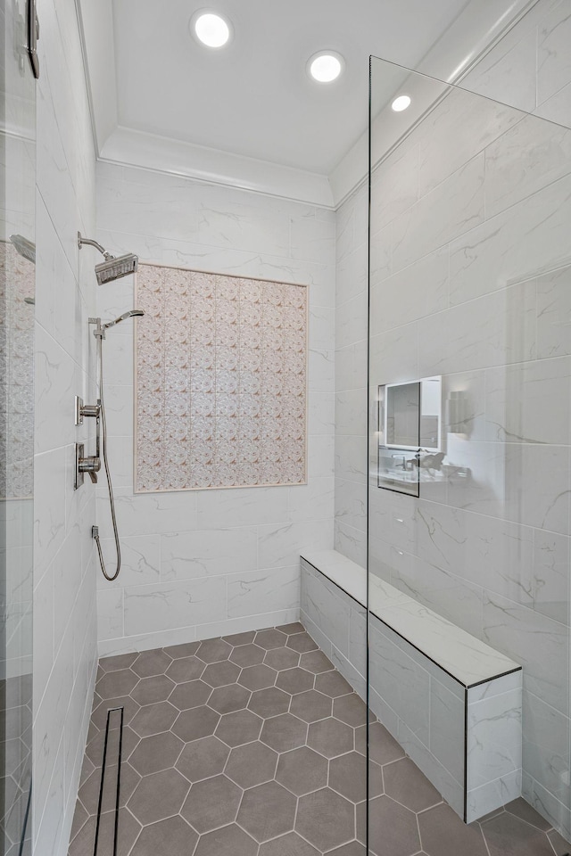 bathroom featuring crown molding, tile walls, and a tile shower