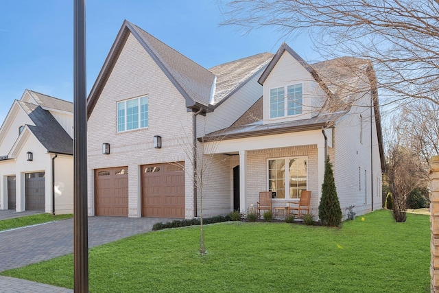 view of front of home with a garage, a front yard, and covered porch