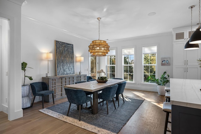 dining space with ornamental molding and wood-type flooring