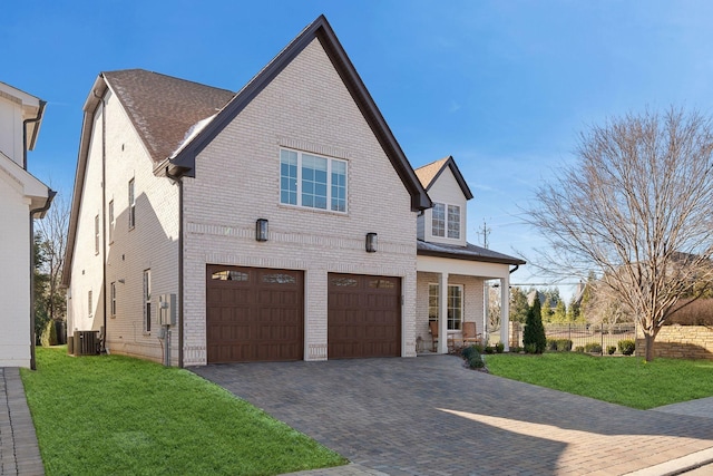 view of front of property with a garage, central AC, and a front yard