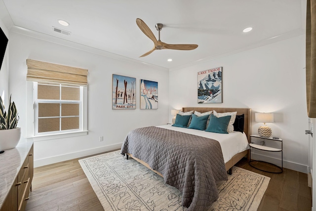 bedroom featuring ceiling fan, ornamental molding, and light hardwood / wood-style flooring