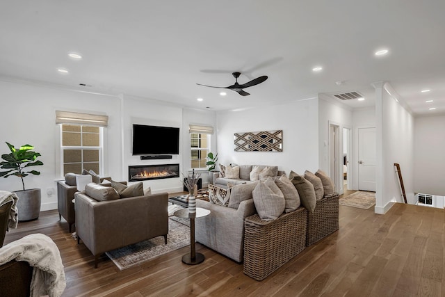 living room with ceiling fan, ornamental molding, and dark hardwood / wood-style flooring