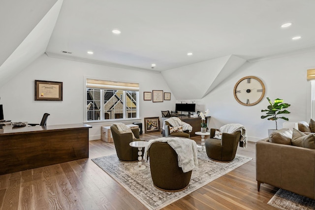 living room with ornamental molding, lofted ceiling, and hardwood / wood-style floors