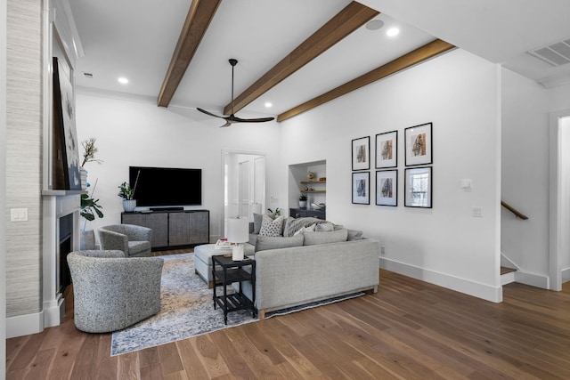 living room with hardwood / wood-style flooring, ceiling fan, and beam ceiling