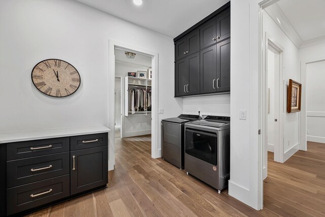 kitchen with crown molding, light hardwood / wood-style flooring, and washing machine and dryer