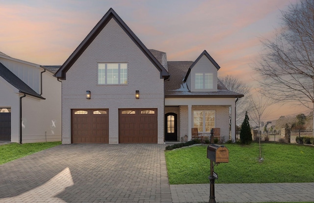 view of front of property featuring a porch, a yard, and a garage