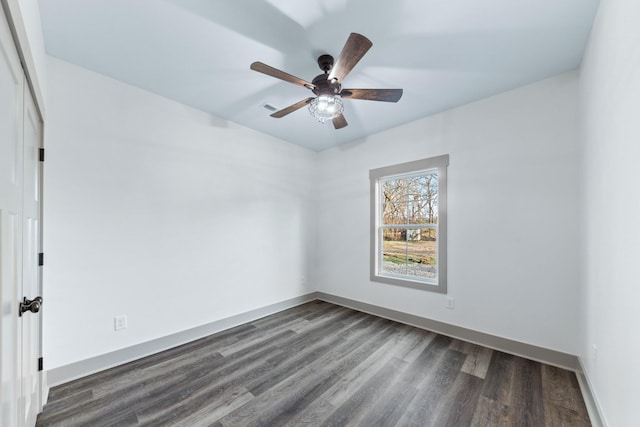 spare room featuring dark wood-type flooring and ceiling fan