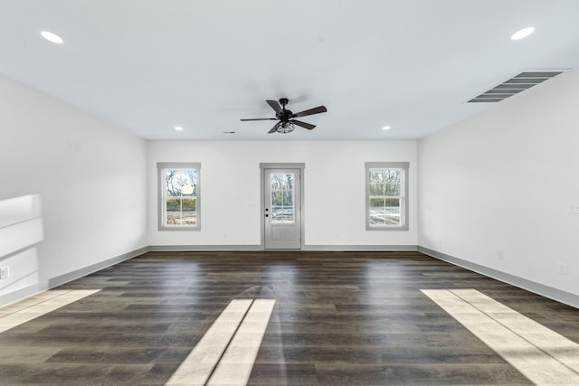 spare room with dark hardwood / wood-style floors, plenty of natural light, and ceiling fan