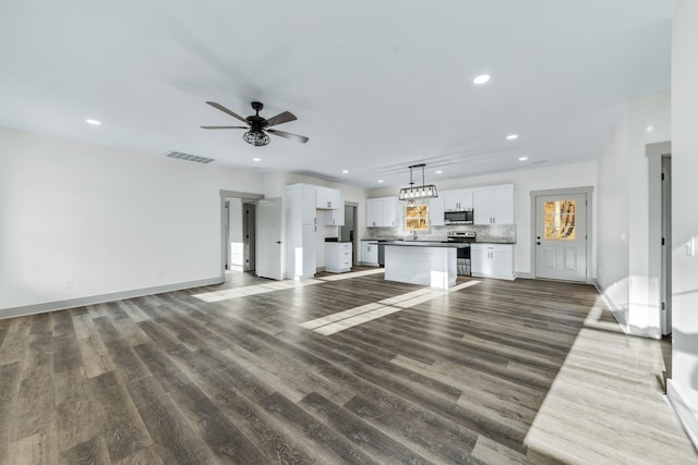 unfurnished living room featuring ceiling fan and dark hardwood / wood-style floors