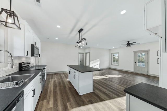 kitchen with stainless steel appliances, a center island, pendant lighting, white cabinets, and sink