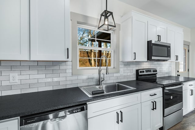 kitchen with tasteful backsplash, sink, stainless steel appliances, white cabinets, and dark hardwood / wood-style flooring