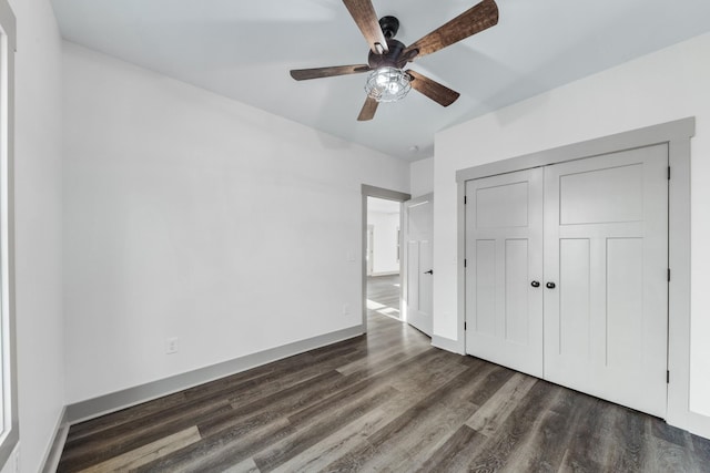 unfurnished bedroom with ceiling fan, dark wood-type flooring, and a closet