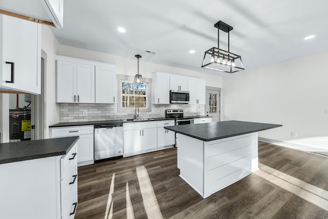 kitchen featuring decorative light fixtures, stainless steel appliances, and white cabinetry