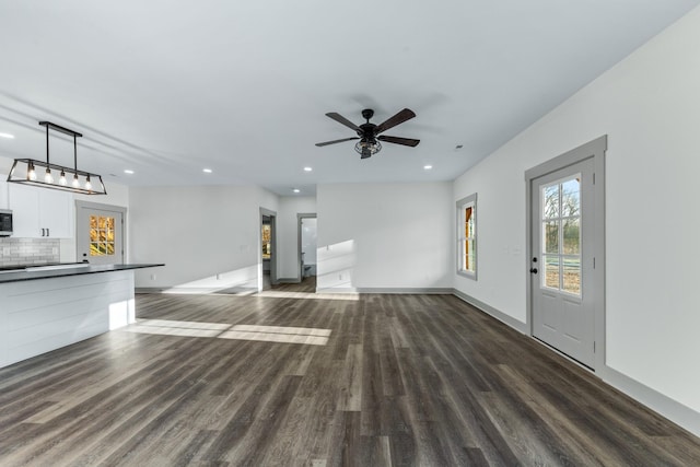 unfurnished living room with ceiling fan and dark hardwood / wood-style flooring