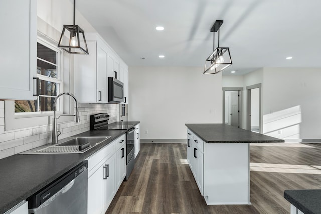 kitchen with a center island, appliances with stainless steel finishes, white cabinetry, and pendant lighting