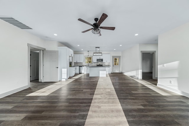 unfurnished living room with ceiling fan, dark hardwood / wood-style floors, and sink