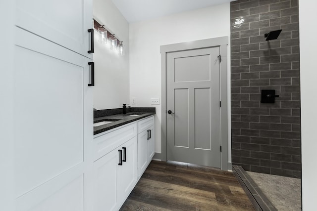 bathroom featuring vanity, wood-type flooring, and tiled shower