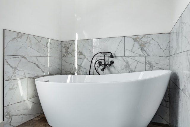 bathroom with hardwood / wood-style floors and a tub