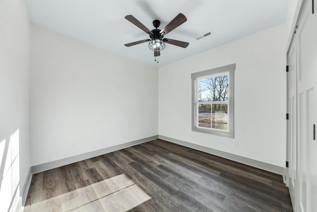 unfurnished room with ceiling fan and dark wood-type flooring