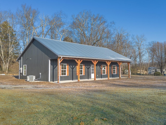 view of front of house with central AC unit and a front yard