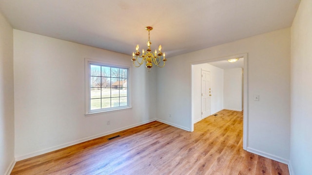 unfurnished room with a chandelier and light wood-type flooring