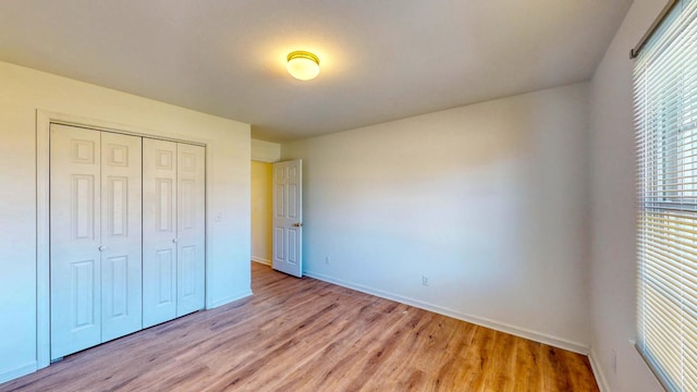 unfurnished bedroom with a closet and light hardwood / wood-style flooring