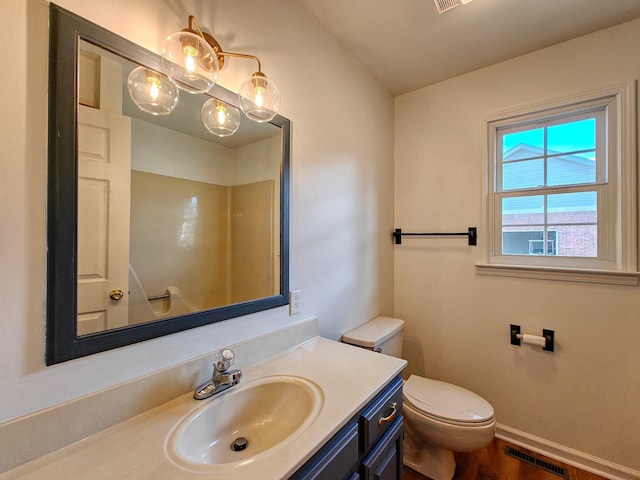 bathroom featuring toilet, vanity, and hardwood / wood-style floors