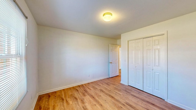 unfurnished bedroom with a closet and light hardwood / wood-style flooring