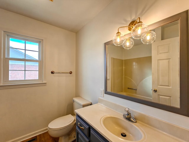 bathroom with toilet, vanity, and hardwood / wood-style floors