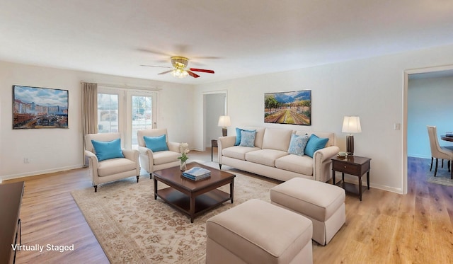 living room with ceiling fan and light hardwood / wood-style flooring