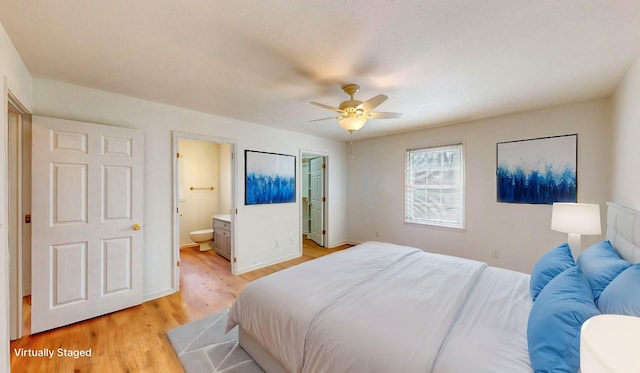 bedroom featuring light wood-type flooring, ceiling fan, and connected bathroom