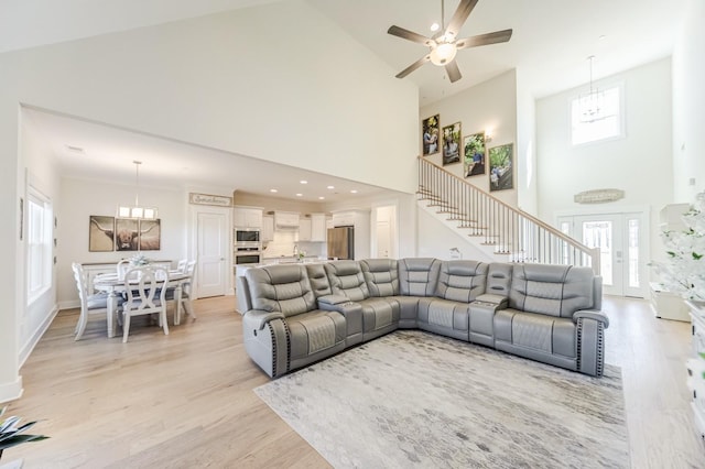 living room with light hardwood / wood-style flooring, high vaulted ceiling, and french doors