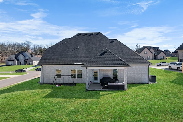 back of property featuring central air condition unit, a yard, and a patio