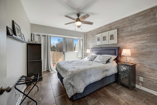 bedroom featuring ceiling fan and wood walls