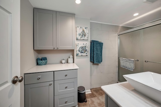 bathroom featuring a shower with shower door, hardwood / wood-style flooring, and vanity