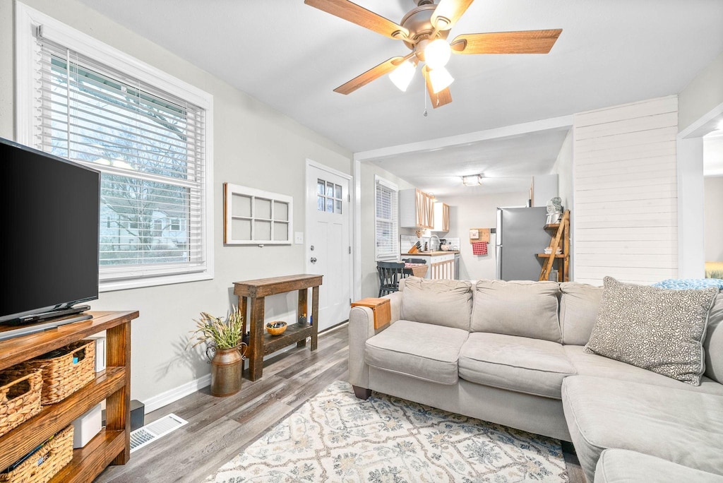 living room with light hardwood / wood-style floors and ceiling fan