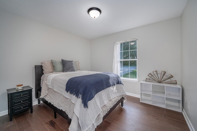 bedroom with dark wood-type flooring