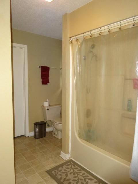 bathroom featuring toilet and shower / bath combination with curtain