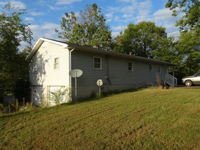 back of property featuring a yard