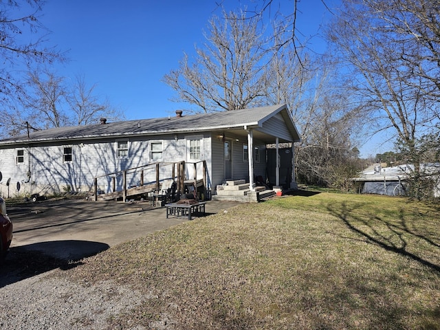 rear view of property featuring a lawn