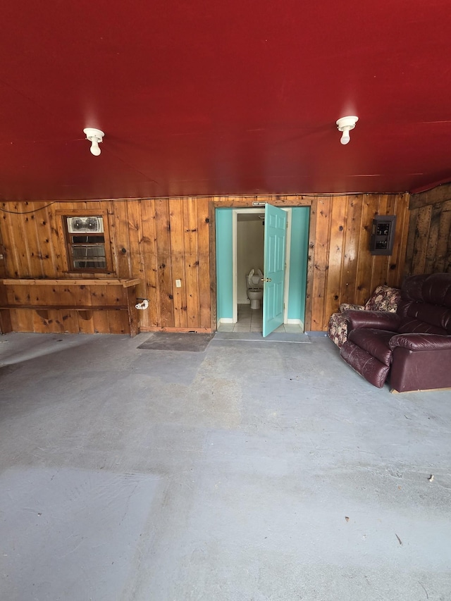 unfurnished living room featuring wood walls