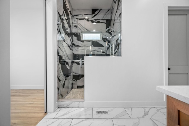 bathroom with a shower with door and vanity