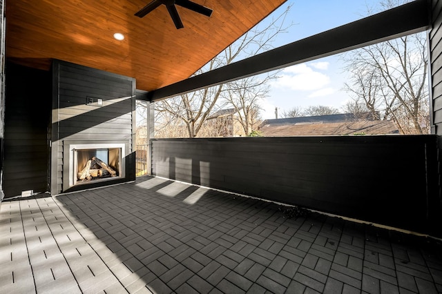 view of patio with ceiling fan and an outdoor fireplace