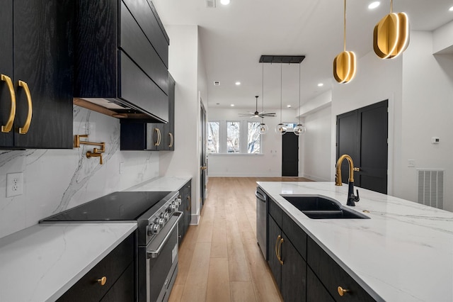 kitchen with stainless steel appliances, decorative backsplash, decorative light fixtures, light stone counters, and sink