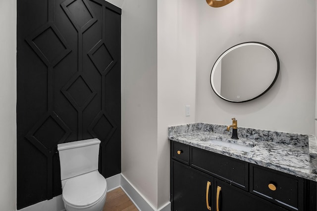 bathroom featuring toilet, wood-type flooring, and vanity