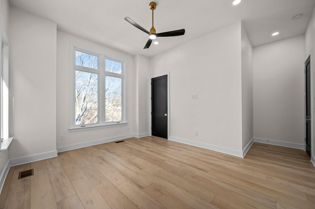 empty room with ceiling fan and light hardwood / wood-style floors