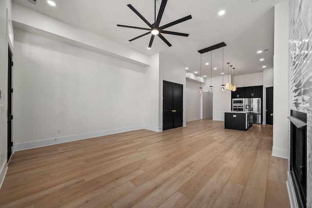 unfurnished living room with ceiling fan and light wood-type flooring