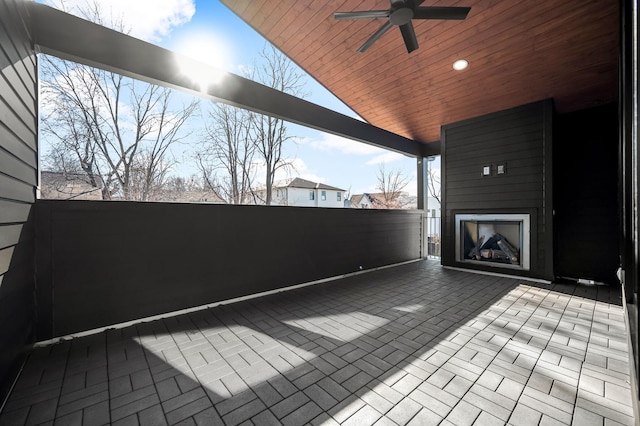 view of patio with ceiling fan and a fireplace